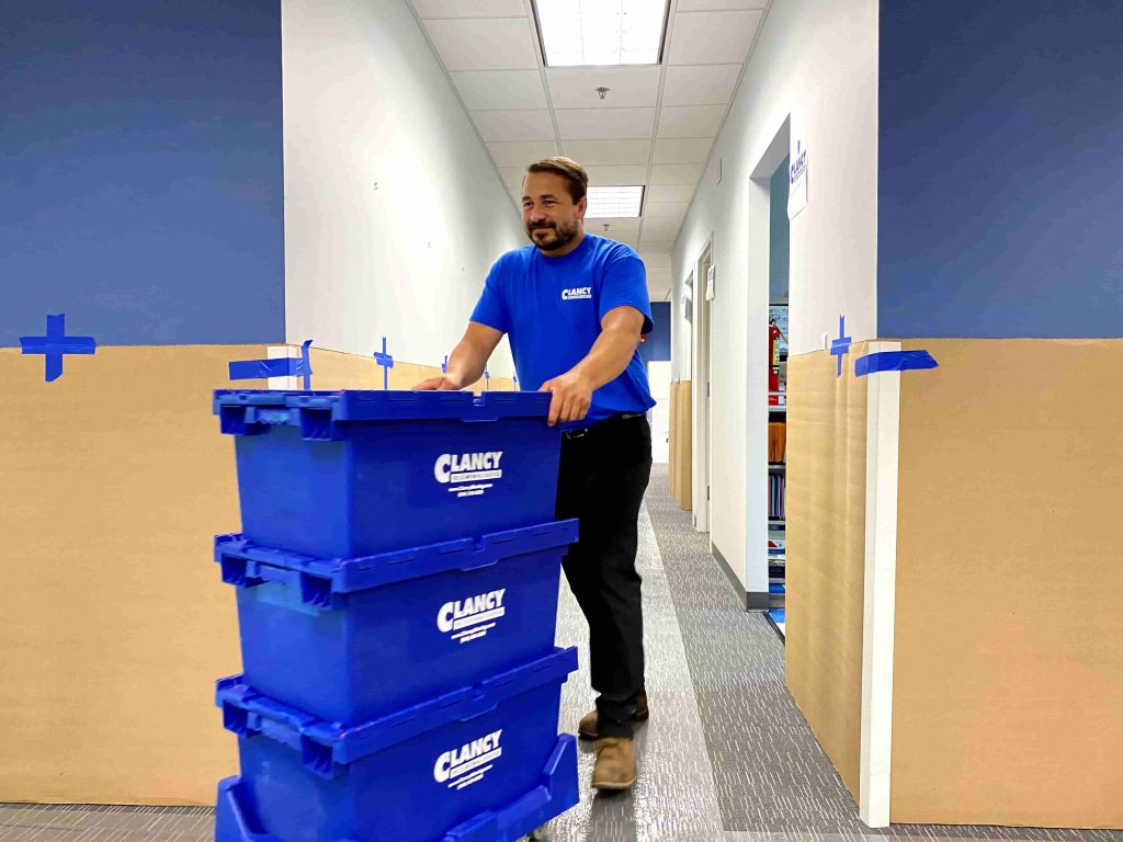 men pushing storage boxes