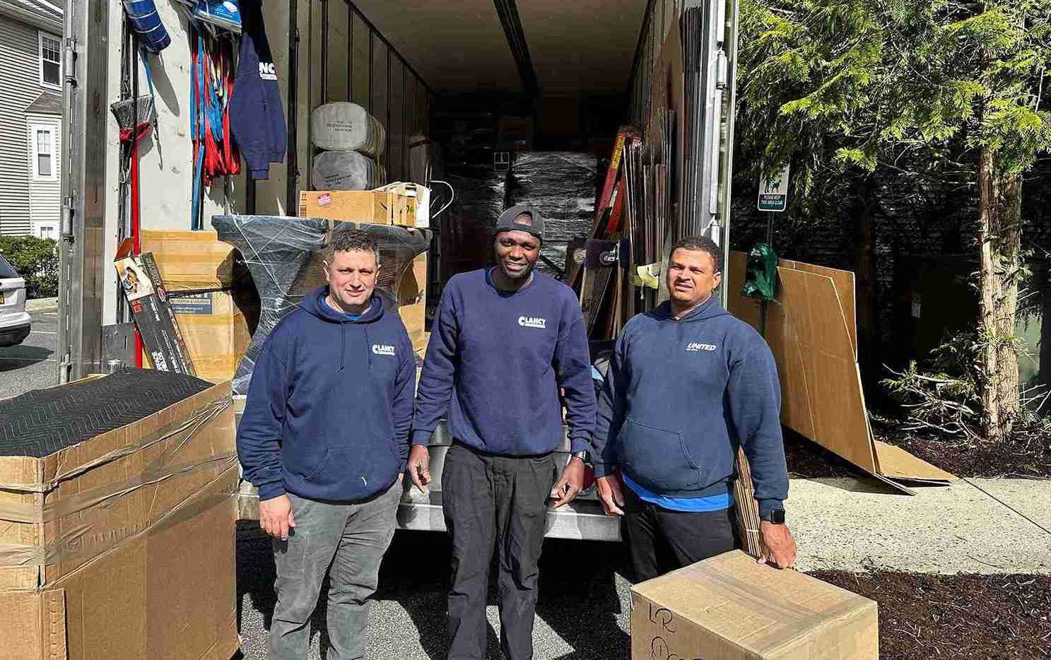 movers team standing behind the moving truck